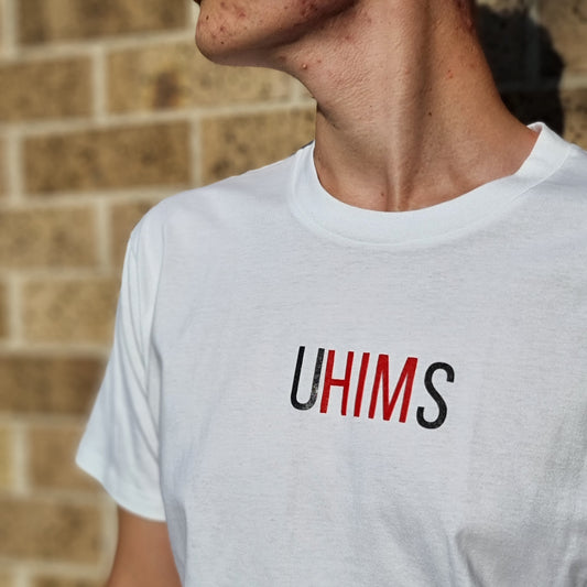 White tee with wordle like text. UHIMS written across front chest. Approximately 8 cms high and 20 cm wide across chest. U - Black ink, HIM - Red ink S - Black ink. 