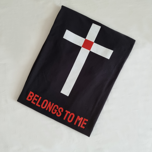 BELONGS TO ME tees. BLack. Blank front. Back design is  white simple cross with red square at intersection point of cross that represents Christs blood shed on the cross. Red ink underneath in capitol letters states - BELONGS TO ME. Explaining that the cross is an identification symbol for Christians.  Large back print. Long line shirt . Pic is of folded shirt showing design 