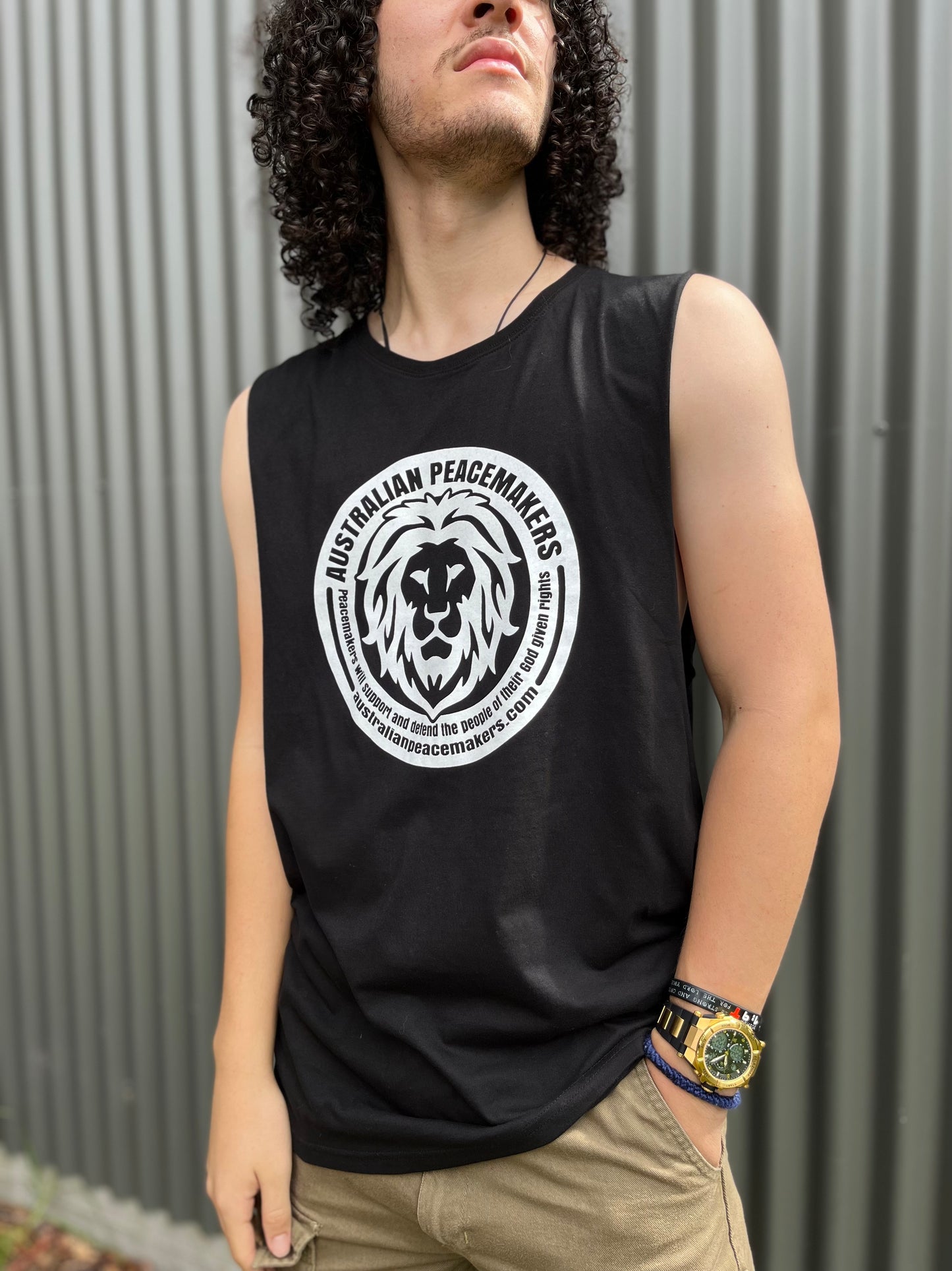 Black muscle top with white inked print on front. Print design - lion image with Australian Peacemakers quotation. Peacemakers will support and defend the people of their God given rights. BLANK back 