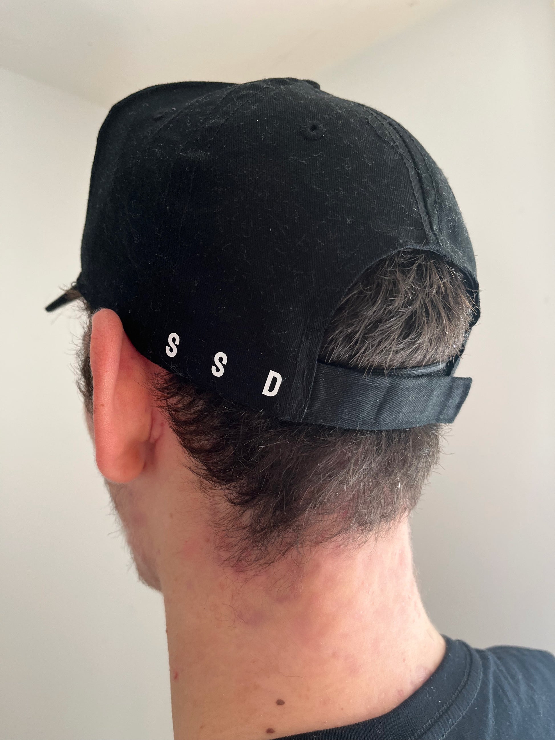 Hat/ cap on young male head - showing the back adjustable velcro straps and the SSD acronym on left 